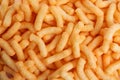 Many tasty cheesy corn puffs as background, top view Royalty Free Stock Photo