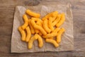 Many tasty cheesy corn puffs on wooden table, top view Royalty Free Stock Photo