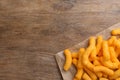 Many tasty cheesy corn puffs on wooden table, top view. Space for text Royalty Free Stock Photo