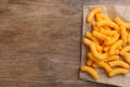 Many tasty cheesy corn puffs on wooden table, top view. Space for text Royalty Free Stock Photo