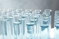 Many test tubes with light blue liquid on grey background