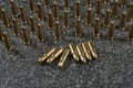 many Tokarev pistol cartridges on a gray granite background - six cartridges are lying in the middle and the rest is standing