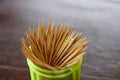 Many toothpicks are in a green plastic box.