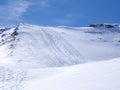 Many tracks of backcountry skiers on a mountain peak in the Swiss Alps