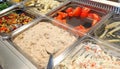 many trays of cooked and raw food in the company canteen