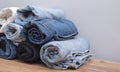 Many twisted jeans of different colors on a wooden surface and grey background Royalty Free Stock Photo