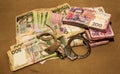 Many Ukrainian money hryvnia. Handcuffs on the money. Corruption in Ukraine. The fight against corruption. Physical evidence of