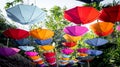 Many umbrellas of different colors hang in the garden, giving people a relaxed feeling