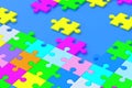 Many unfinished colorful puzzle jiggle pieces on blue background Royalty Free Stock Photo