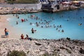 Many unidentified People on the Beach of Hondoq Bay. Island of Gozo. Malta