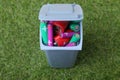 Many used batteries in recycling bin on green grass Royalty Free Stock Photo
