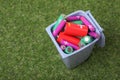 Many used batteries in recycling bin on green grass, above view. Space for text Royalty Free Stock Photo