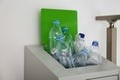 Many used plastic bottles in metal bin indoors, closeup. Recycling problem Royalty Free Stock Photo