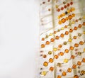 Many various amber necklaces on a glass shelf