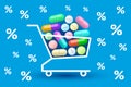 Many various tablets and pills in shopping cart and percent signs