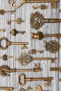 Many vintage keys on a light wooden background, vertical frame Royalty Free Stock Photo