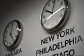 Many wall clocks on the white wall of business office showing time of different cities of the world