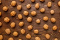 many walnuts with shells evenly spread out on brown wooden surface Royalty Free Stock Photo