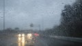 Many water drops on a rainy day in the windshield of a car driving in a road Royalty Free Stock Photo