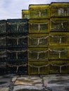 Green and yellow lobster traps stacked on the stone dock