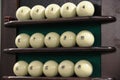 Many white balls on the shelf-stand for billiard balls in a row for playing Russian Billiards. Russian sports, vintage fun game