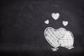 Many white hearts chalk symbol on chalkboard.