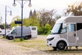 Many white modern campervan recreational motor home vehicles parked in row at camper park site Magdeburg city against Royalty Free Stock Photo