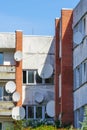 Many white parabolic satellite antenna dishes hanged on wall of suburban perfab block of flats Royalty Free Stock Photo