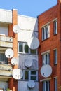 Many white parabolic satellite antenna dishes hanged on wall of suburban perfab block of flats Royalty Free Stock Photo