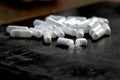 Many white pills on black background. Broken pilll and spilled dust. White tablets, medication Royalty Free Stock Photo