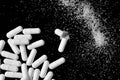 Many white pills and white dust on black background. White tablets, medication Royalty Free Stock Photo