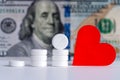 White pills and red heart on hundred dollar bill background