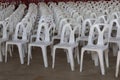Many white plastic chairs lined up in a conference concept room.