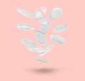 Many white plates falling on pastel pink background