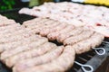Many white sausages in a row to roast on a barbecue with charcoal Royalty Free Stock Photo