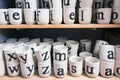 Many white tea mugs with letters on the shelf of the store Royalty Free Stock Photo