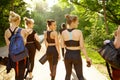 Many women with mats on sidewalk, group yoga