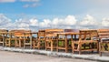 Many wood benches with sky clouds.