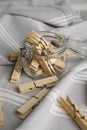 Many wooden clothespins and glass jar on light grey towel