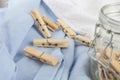 Many wooden clothespins on light blue fabric Royalty Free Stock Photo