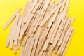Many wooden ice cream sticks in heap on yellow background Royalty Free Stock Photo