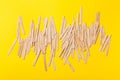 Many wooden ice cream sticks in heap on yellow background Royalty Free Stock Photo