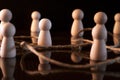 many wooden pawns and on a black background. social distancing