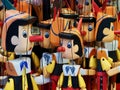 Many wooden Pinocchio puppets at a market