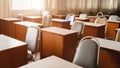 Many wooden tables and chairs well arranged in the university classroom but no student. Empty classroom with no student due to Royalty Free Stock Photo