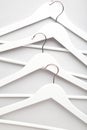 Many wooden white hangers on white wall background Royalty Free Stock Photo