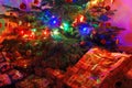 Many Wrapped Presents Under A Lit Christmas Tree