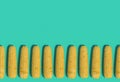 Many yellow corn cobs lie in a row on a turquoise background. Creative decorative composition. Modern Art. 3D rendering.