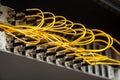 Many yellow fiber optic cables are inserted into the switches in multiple rows. Cable management. Horizontal orientation Royalty Free Stock Photo