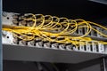 Many yellow fiber optic cables are inserted into the switches in multiple rows. Cable management. Horizontal orientation Royalty Free Stock Photo